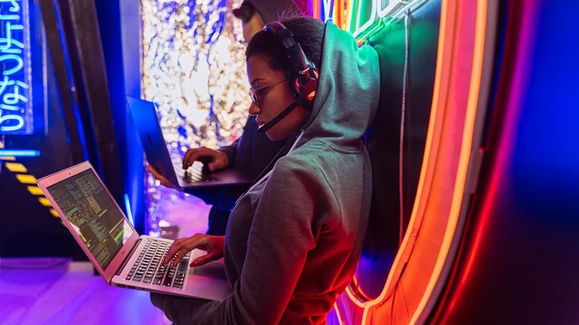 Technology professional working thoughtfully at a laptop